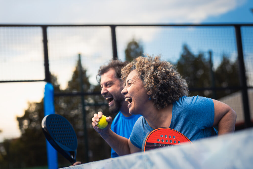 Woman and man enjoying outdoor pickleball on a reserve pickleball courts